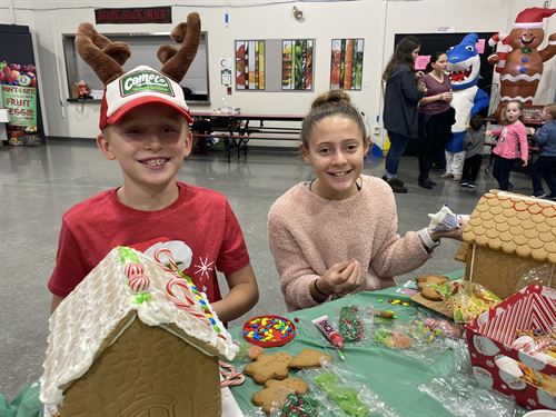 two students building ginger bread houses